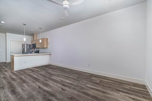 A room with a kitchenette and a ceiling fan.