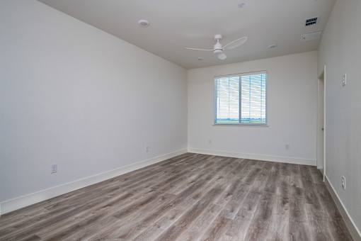 A room with a window and a ceiling fan.