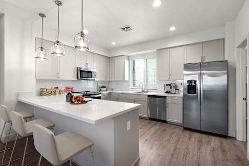 A modern kitchen with a white island and stainless steel appliances.