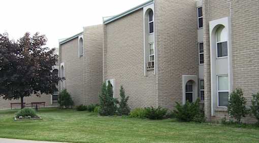 A building with a green roof and a grassy area in front.