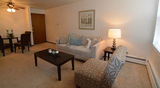 A living room with a couch, coffee table, and lamp.