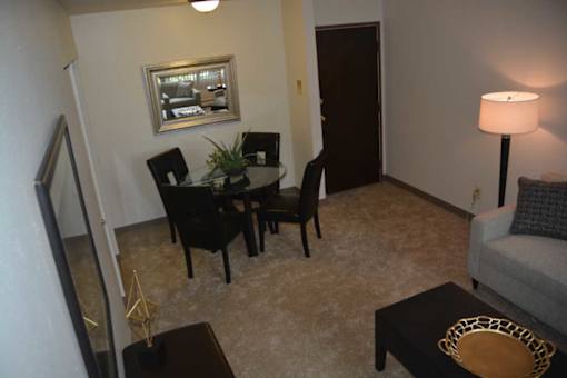 A living room with a black table and chairs.