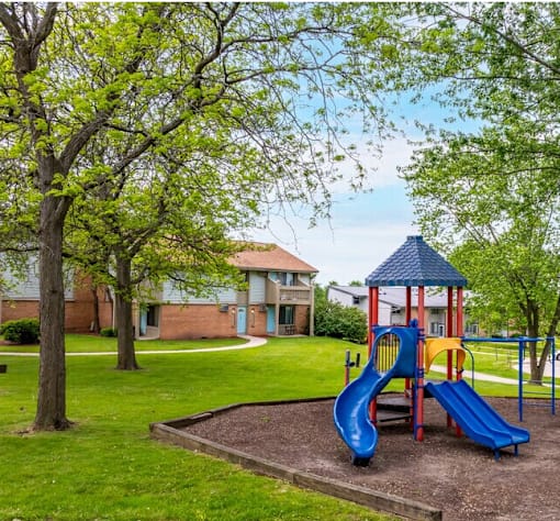A playground with a blue slide and a red and yellow slide.