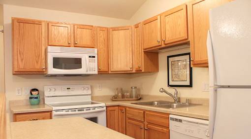 A kitchen with wooden cabinets and white appliances.