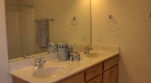 A bathroom with a white sink and a mirror.