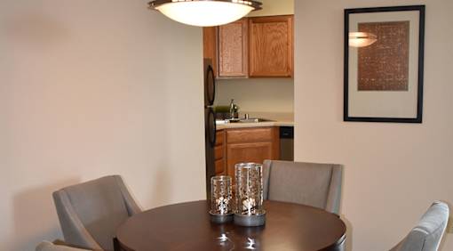 A dining room with a table and chairs.