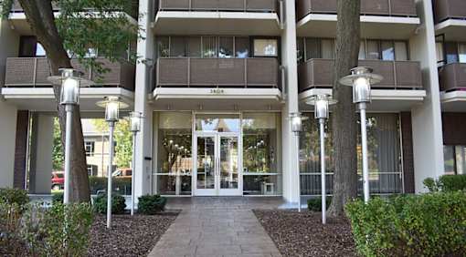 The image shows the front of a building with a glass door entrance and a sign that reads "SID".