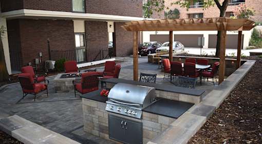 A patio with a grill and seating area.