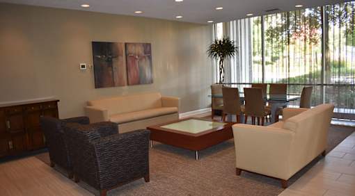 A living room with a couch, chairs, and a table.