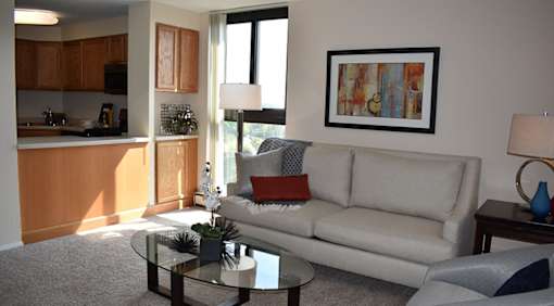 A living room with a couch, coffee table, and a painting on the wall.