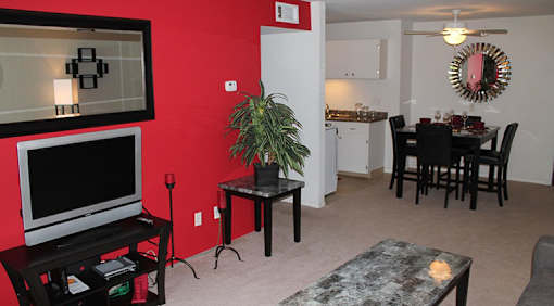 A living room with a red wall and a television.