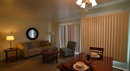 A living room with a couch, chair, and dining table.