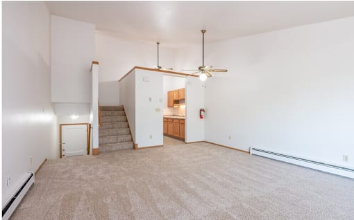 A room with a staircase and a ceiling fan.