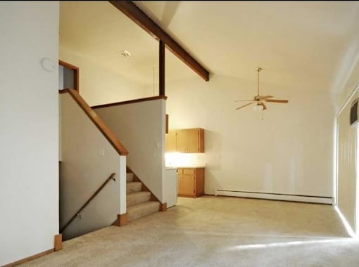 A room with a staircase and a ceiling fan.