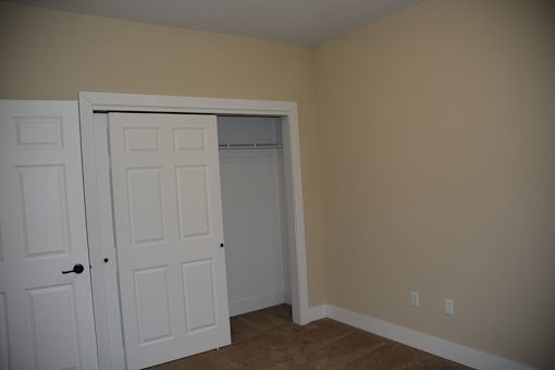 A room with two white doors and a carpeted floor.