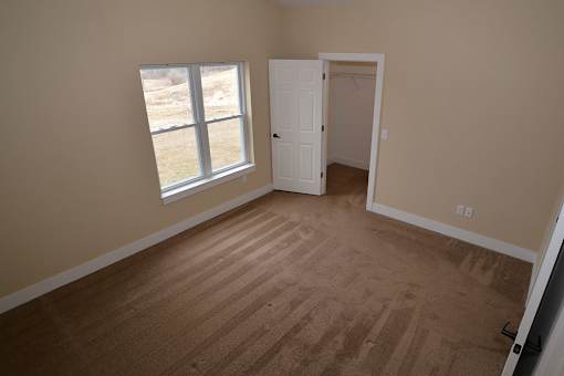 A room with a brown floor and a white door.