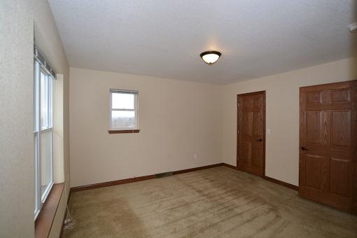 A room with a window and two doors.