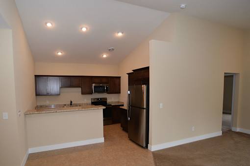 A kitchen with a refrigerator, microwave, and oven.