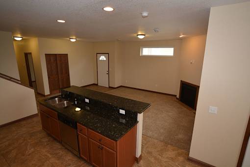 A kitchen with brown cabinets and a black countertop.