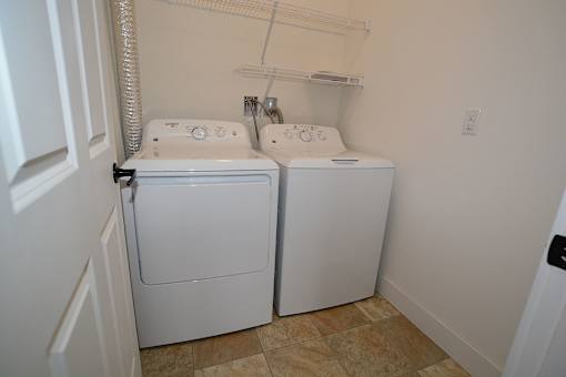 A small laundry room with a washer and dryer.