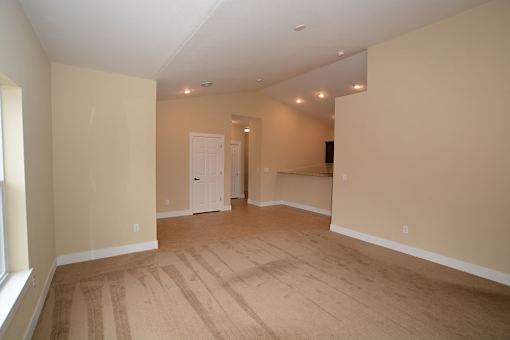 A room with a white door and a window on the left side.