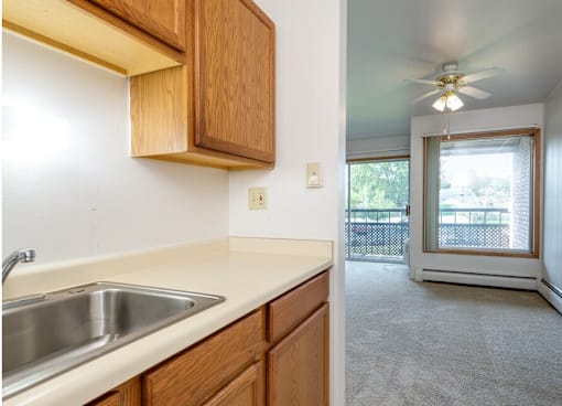A kitchen with wooden cabinets and a stainless steel sink.
