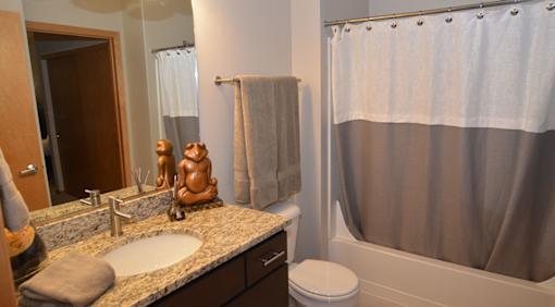 A bathroom with a toilet, sink, and shower curtain.