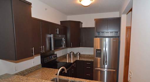 A kitchen with brown cabinets and a black stove top.