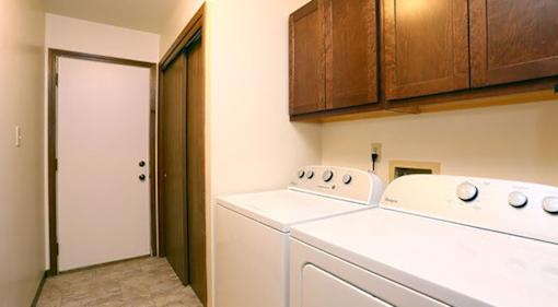 A white washing machine sits in a laundry room.