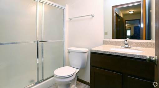 A white toilet sits next to a sink in a bathroom.