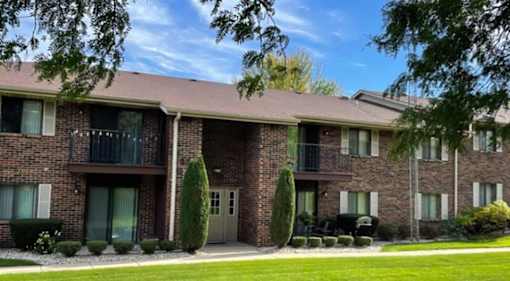 A brick apartment building with a balcony on the second floor.