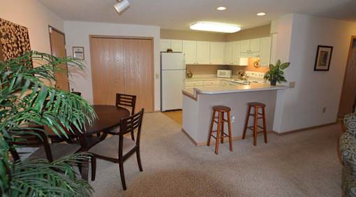 A kitchen with a table and chairs in the middle of the room.