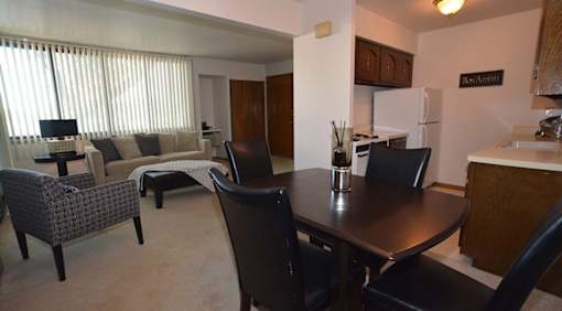 A dining room with a table and chairs.