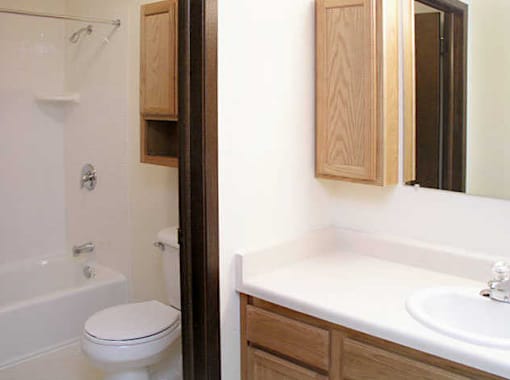 A white toilet sits next to a white sink in a bathroom.