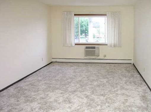 A room with a window and a fan on the wall.