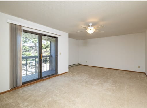 A room with a sliding glass door leading to a balcony.