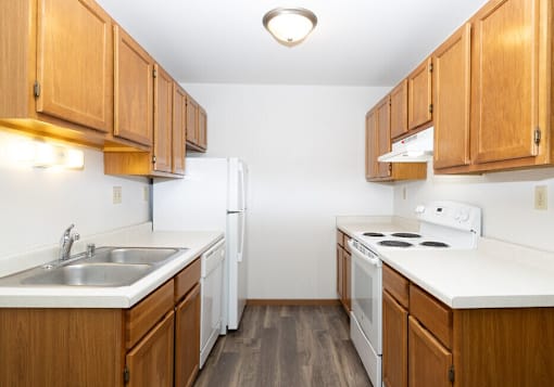A kitchen with wooden cabinets and white appliances.