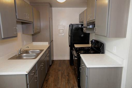 A kitchen with a black refrigerator and stove.