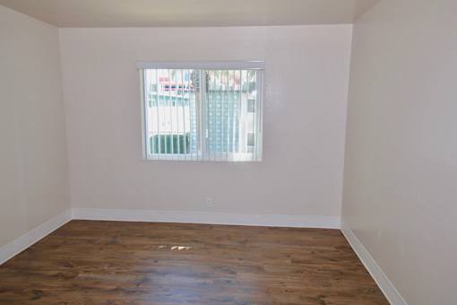 A room with a window and wooden floors.