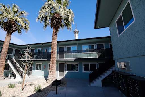 A building with palm trees in front of it.