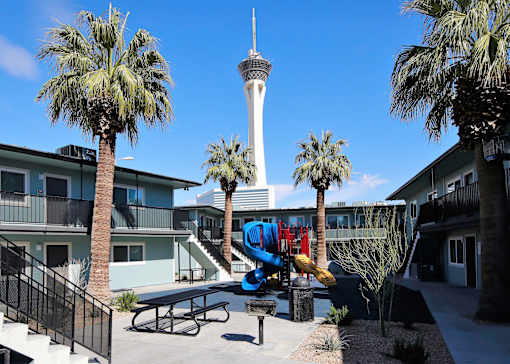 A playground with a slide and a tower in the background.