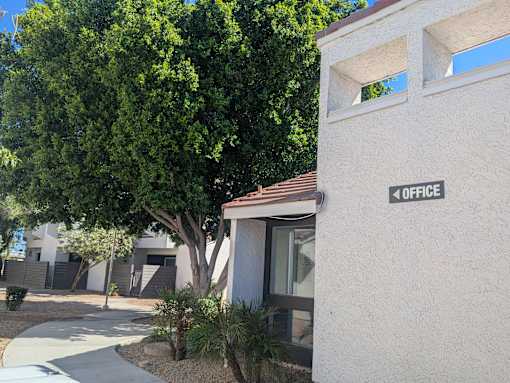 A white building with a sign that says "OFFICE" on the side.