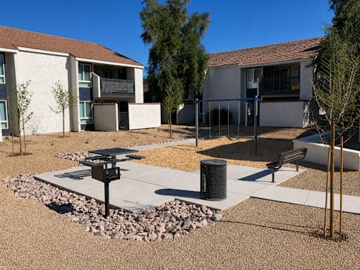 A courtyard with a bench, a trash can, and a fire hydrant.