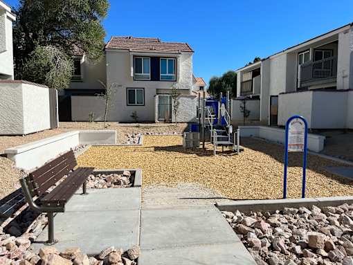 A park area with a bench and a playground.