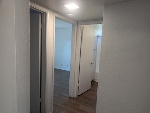 A hallway with a door on the left and another door on the right.