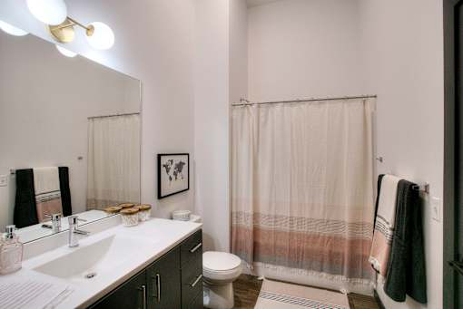 Modern bathroom with white vanity and shower at The Traveler Apartments, Nebraska