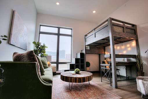 Loft bed over workspace with string lights at The Traveler Apartments, Omaha, NE