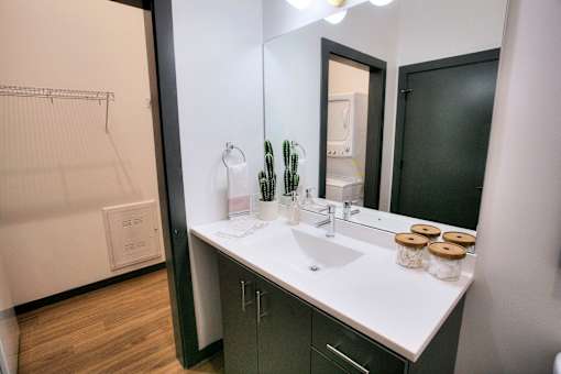 Bathroom vanity with rectangular sink and black framed mirror at The Traveler Apartments, Omaha