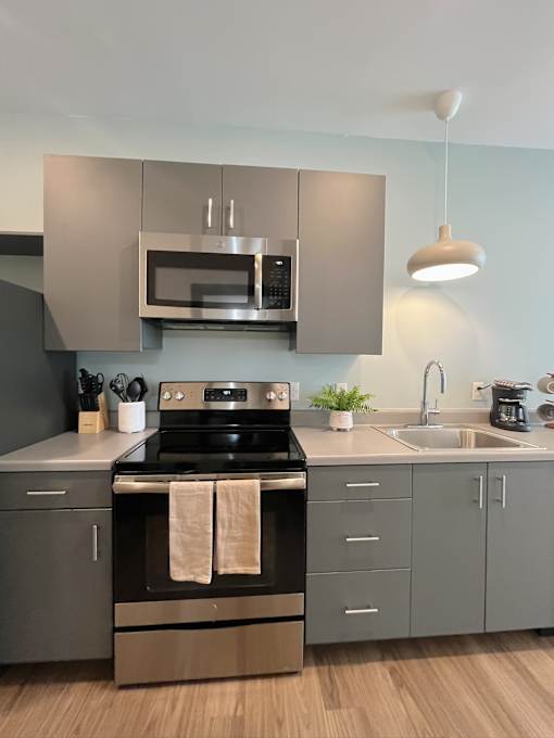 Contemporary kitchen with gray cabinets and stainless appliances at The Traveler Apartments, Nebraska, 68131