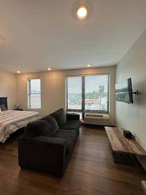 Studio apartment with sofa bed and wall mounted tv at The Traveler Apartments, Omaha, NE